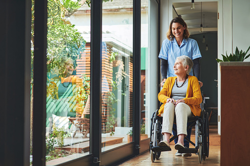 caregiver helping out an elderly woman