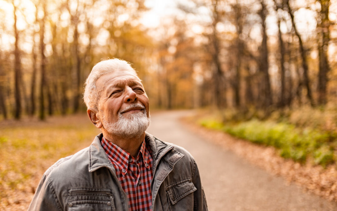 portrait of a senior man enjoying an autumn day in the forest